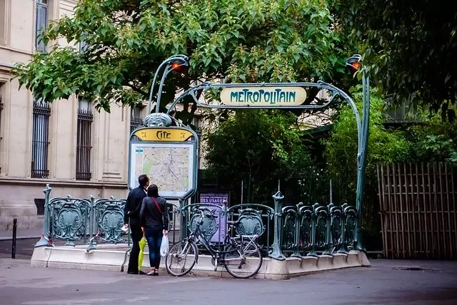 Art Nouveau Pariser Métro-Eingang zur Station Cité, mit zwei Personen, die eine Karte betrachten, und einem geparkten Fahrrad
