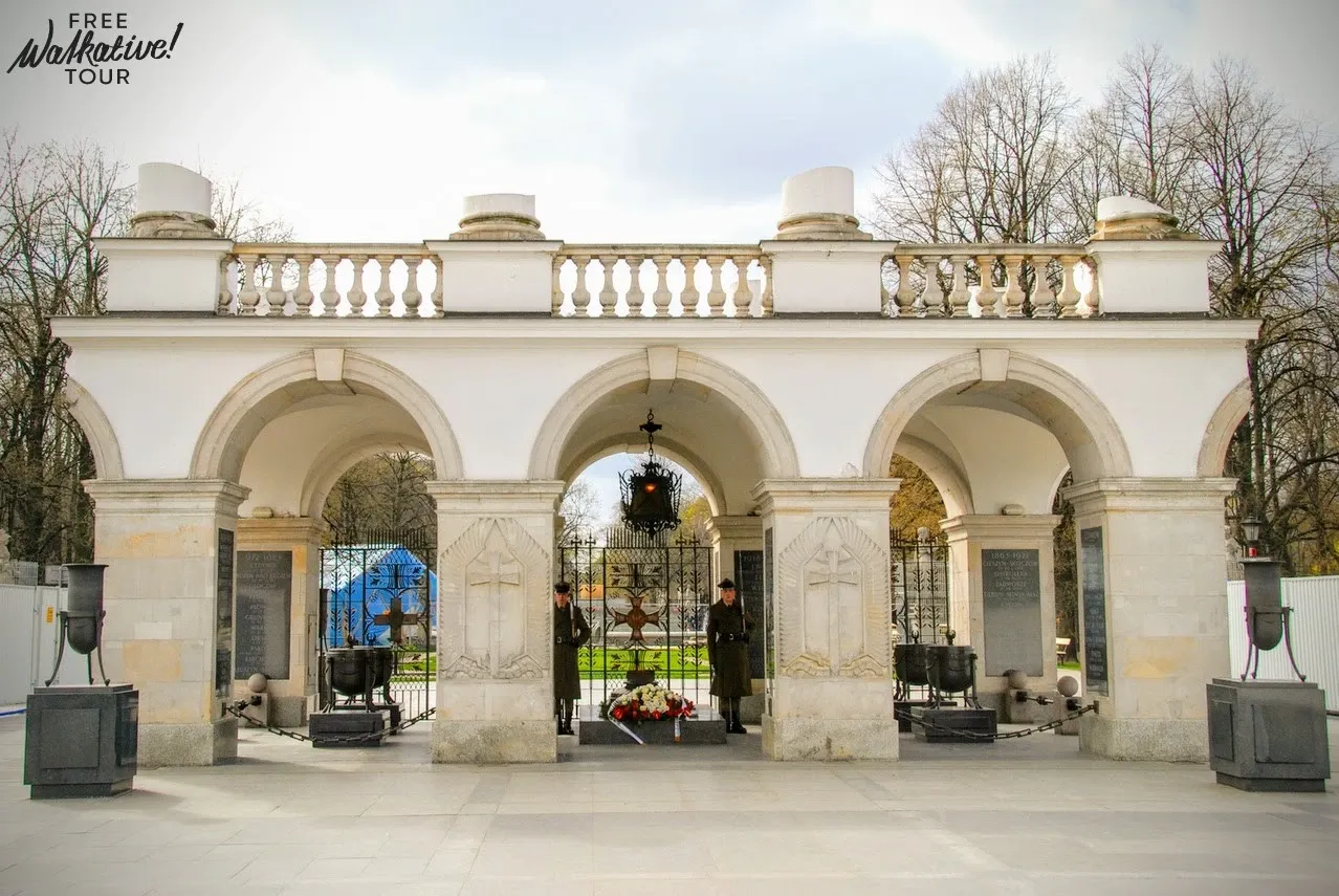 The Tomb of the Unknown Soldier in Warsaw, a white arcade with three arches, guarded by two soldiers in uniform.