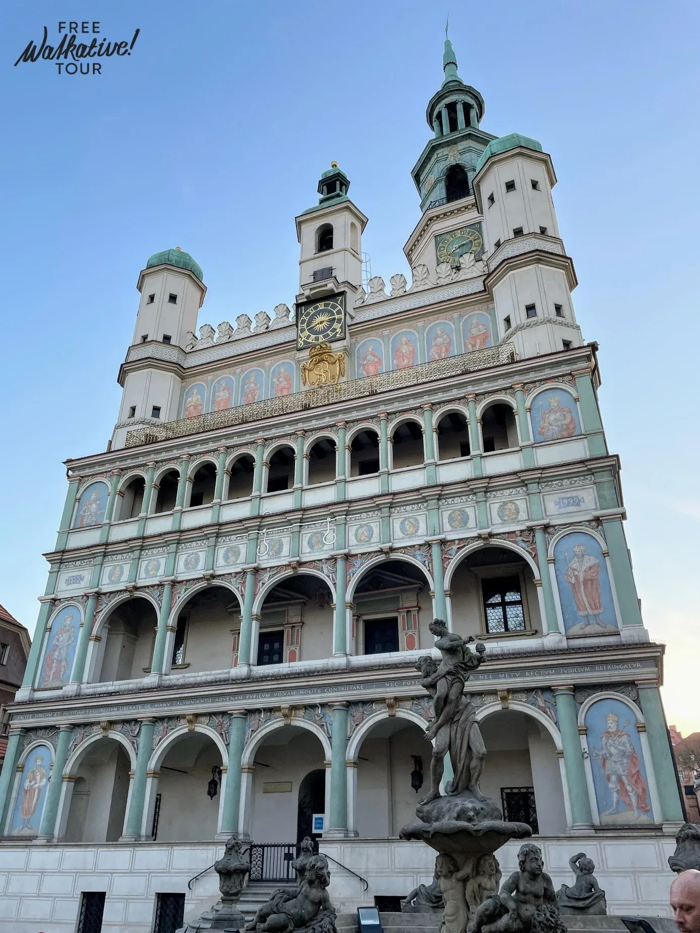 Renaissance Old Town Hall in Poznań, Poland, with detailed facade, clocks, towers, and a fountain in foreground.