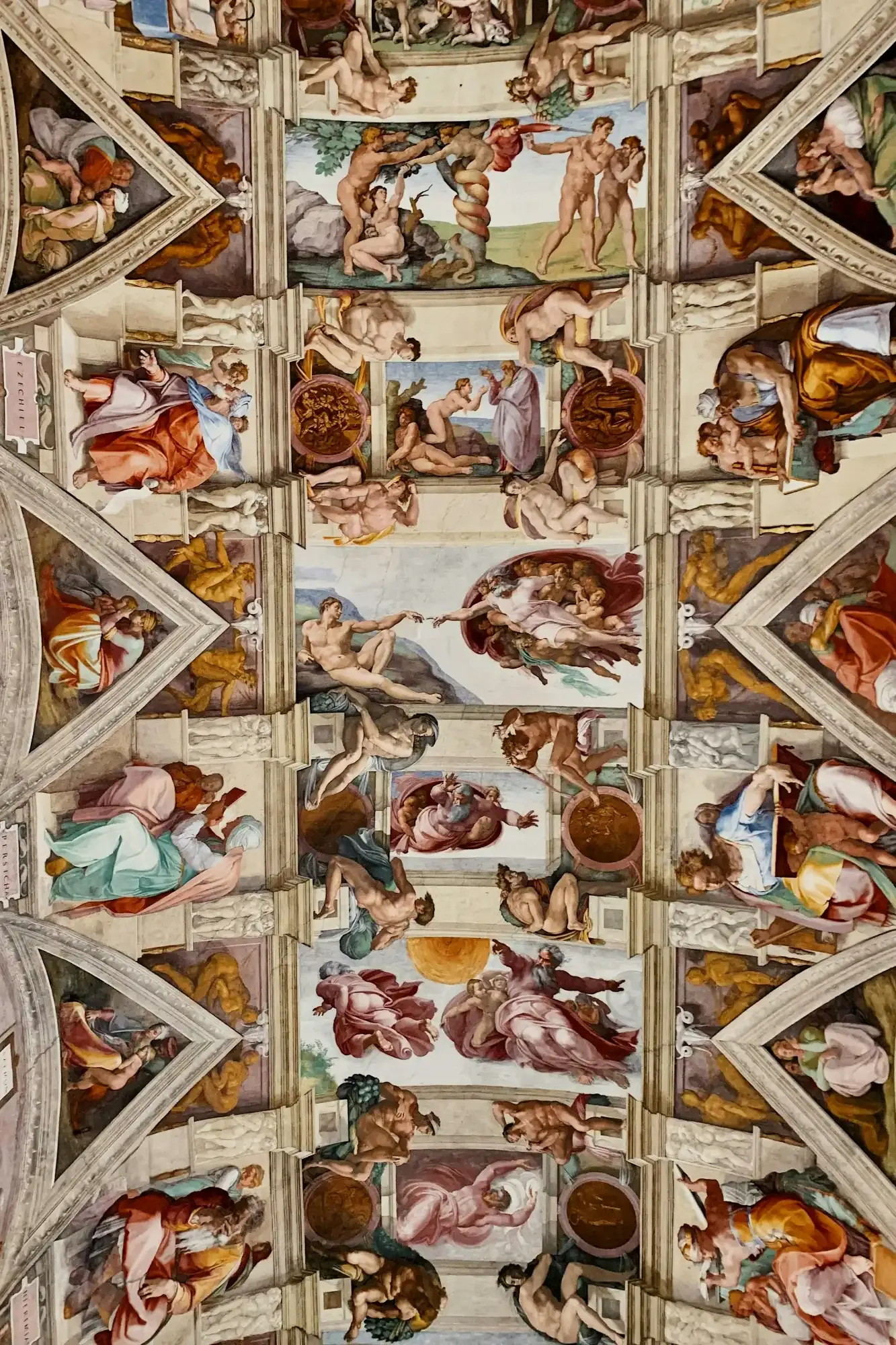 A detailed view of the frescoed ceiling of the Sistine Chapel, with Michelangelo's "The Creation of Adam" visible.