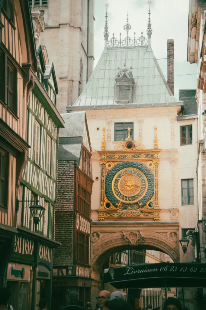 Historic astronomical clock, Gros Horloge, in Rouen, France, visible through an archway, surrounded by half-timbered building