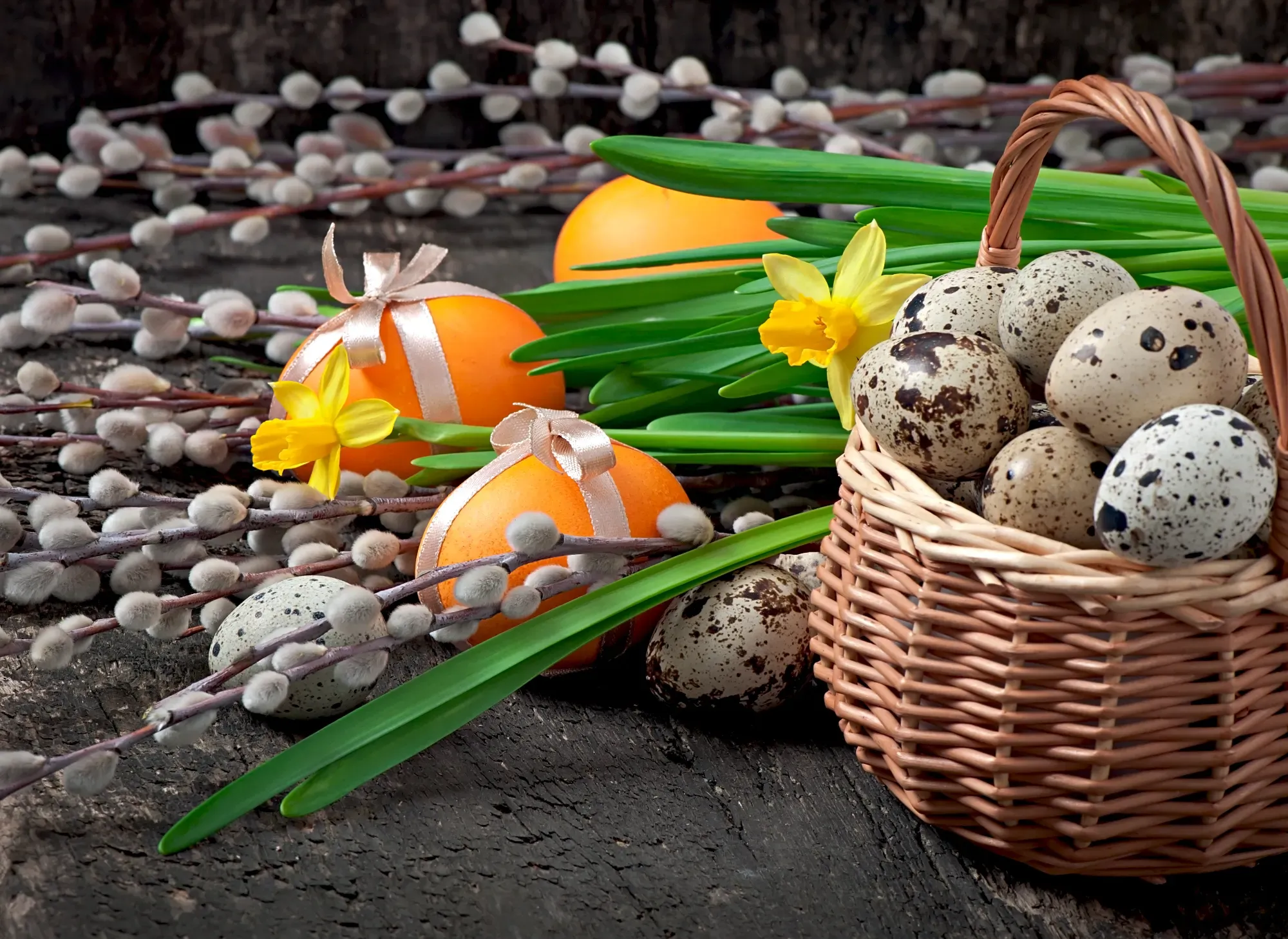 Ceramic Easter bunny, decorated eggs, dried flowers, and a handwritten Happy Easter cardboard tag on a white table.