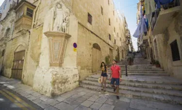 Pareja bajando escaleras en La Valeta, Malta.