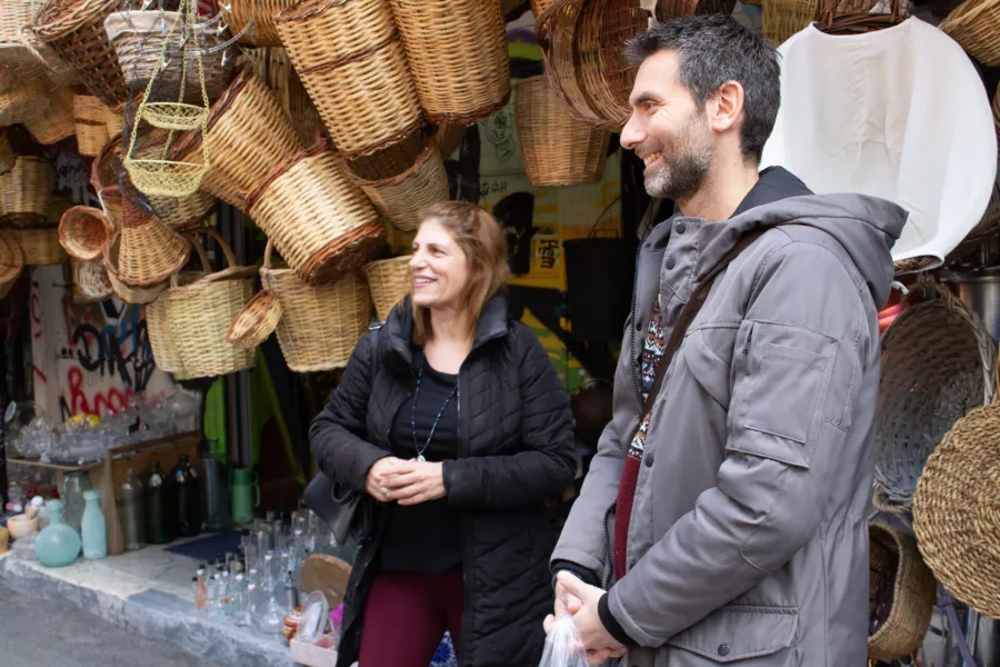 Una pareja feliz en una visita guiada por Atenas, admirando cestas tejidas tradicionales.