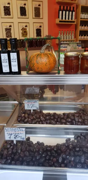 Una colorida exhibición de aceitunas, miel y aceite de oliva en un mercado griego.
