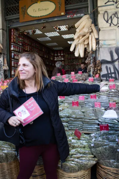 Una turista en un tour gastronómico en Atenas, Grecia, explora una vibrante tienda de especias.