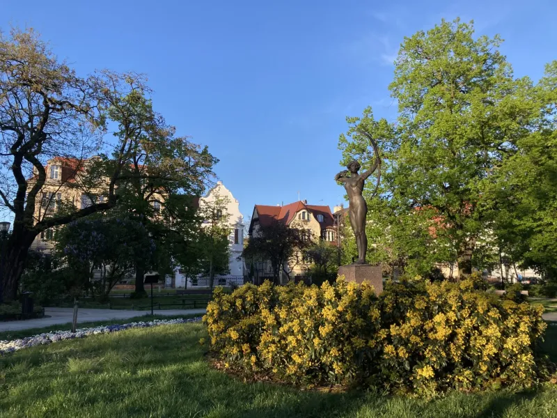 Brązowy posąg łuczniczki w parku w Dreźnie.