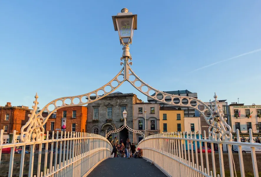 Turistas caminando por el hermoso puente Ha'penny Bridge en Dublín, Irlanda.