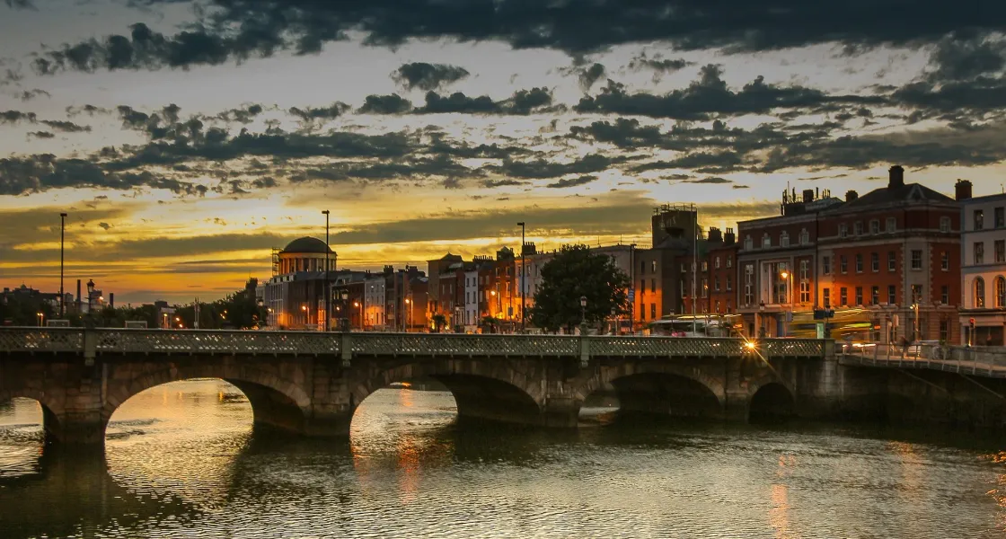 Vista del paisaje urbano de Dublín al atardecer con un puente sobre el río Liffey.