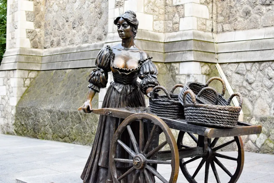 Estatua de bronce de una mujer con un carro en Dublín, Irlanda.
