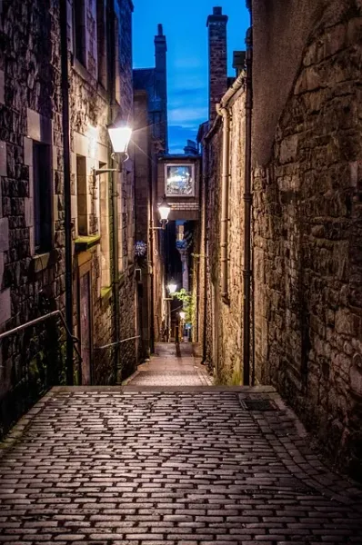 Encantador callejón empedrado en Edimburgo por la noche.