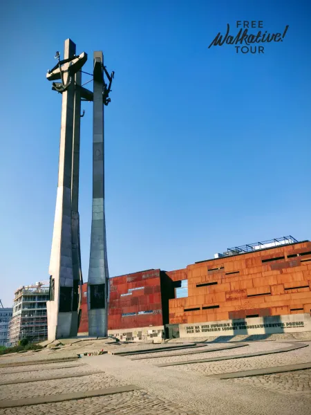Monument to the Fallen Shipyard Workers 1970 in Gdańsk, with three tall crosses and anchors, next to a modern building wit...