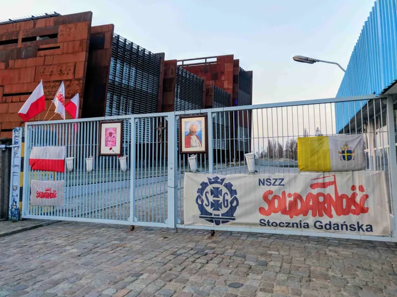 Brama Europejskiego Centrum Solidarności w Gdańsku, z banerami i flagami Solidarności.