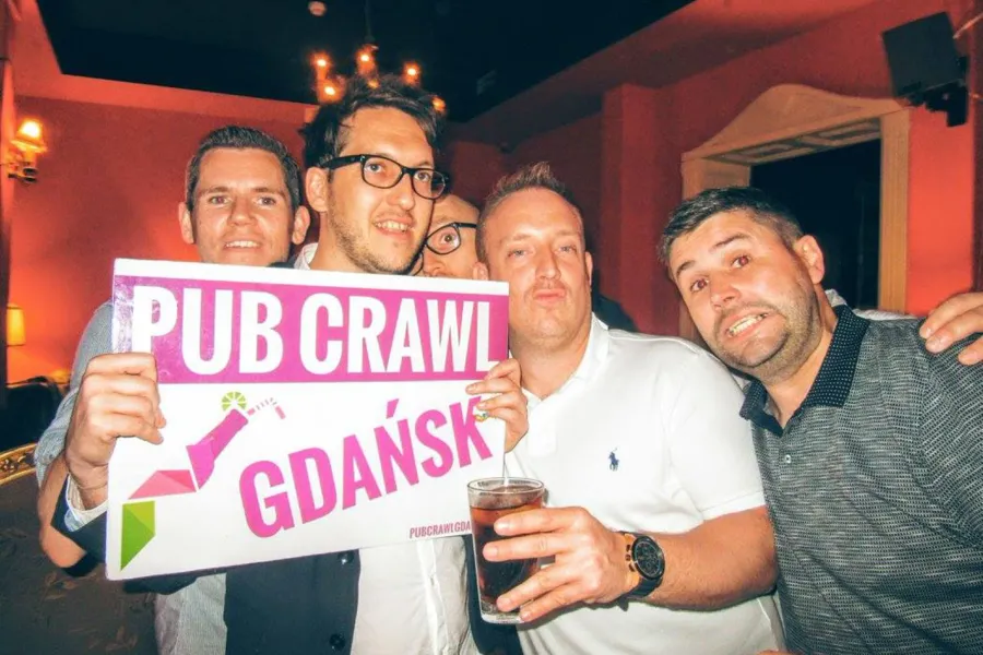 Weseli turyści na pub crawl w Gdańsku.