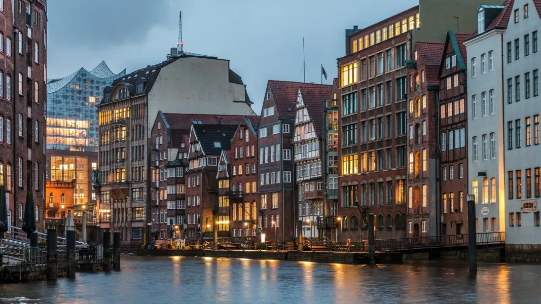 Histórica Speicherstadt de Hamburgo por la noche, edificios iluminados reflejados en el canal.