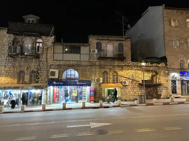 Nachtszene in Jerusalems Altstadt mit historischen Steingebäuden und einer ruhigen Straße.