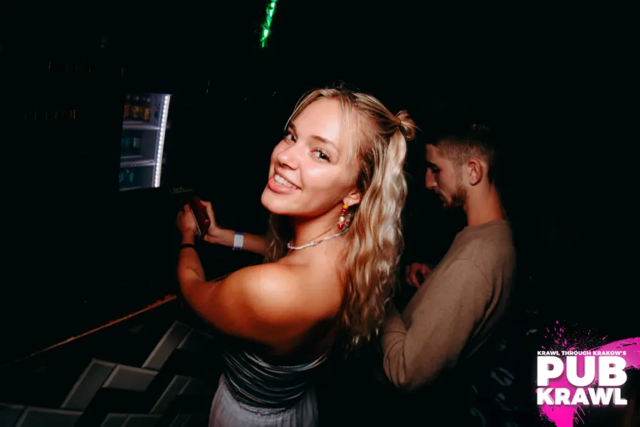 Smiling woman on a pub crawl in Krakow, Poland.