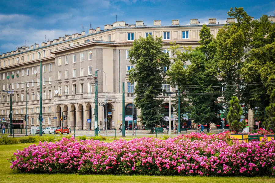 Spacer po Nowej Hucie, dzielnicy Krakowa, z przewodnikiem. Na zdjęciu piękna architektura i kolorowe kwiaty.