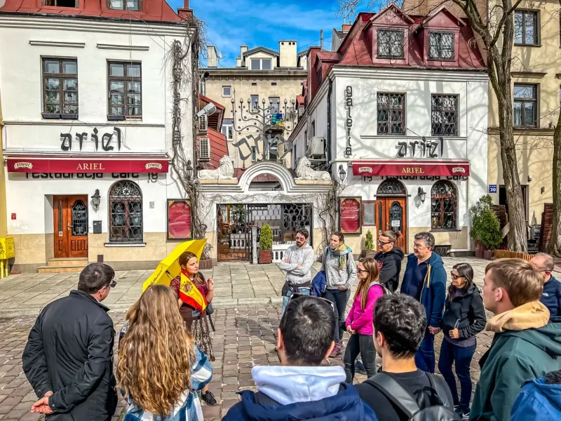 Grupa turystów na wycieczce w krakowskim Kazimierzu, przed restauracją Ariel.
