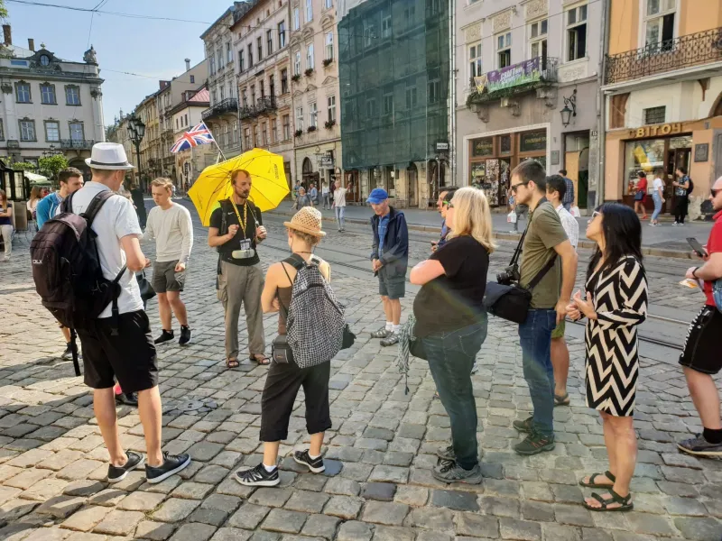 Przewodnik oprowadza grupę turystów po Lwowie na Ukrainie.