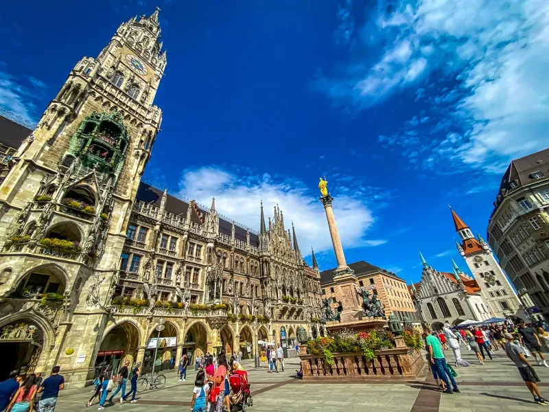 Turyści zwiedzają Marienplatz w Monachium, Niemcy, z nowym ratuszem w tle.