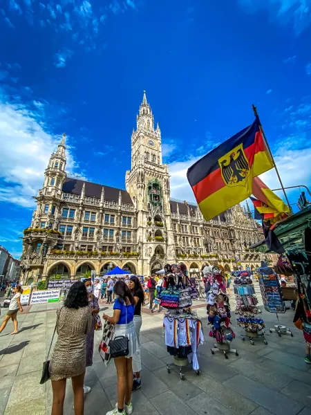 Turyści zwiedzają Marienplatz w Monachium, Niemcy, z nowym ratuszem w tle.