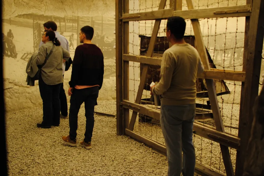 Tourists visiting a somber museum exhibit, reflecting on history.