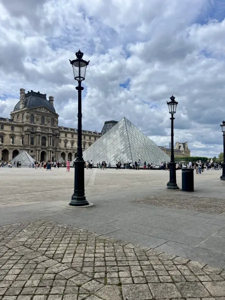 Tourists visit the Louvre Pyramid and Museum in Paris.