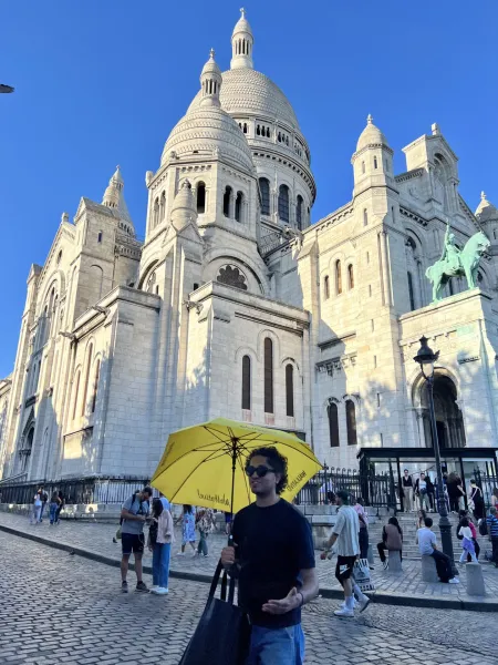 A tour guide in Paris stands before the Sacré-Cœur Basilica in Montmartre.