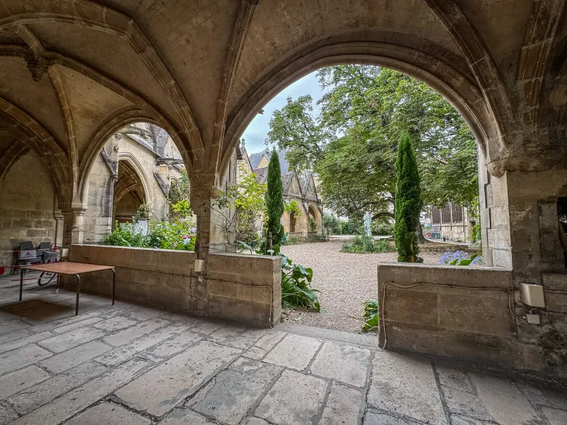 Sereno patio en París, visto a través de antiguos arcos de piedra.