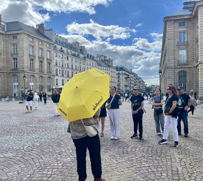 Un guía de Walkative! conduce a un grupo por una plaza parisina.