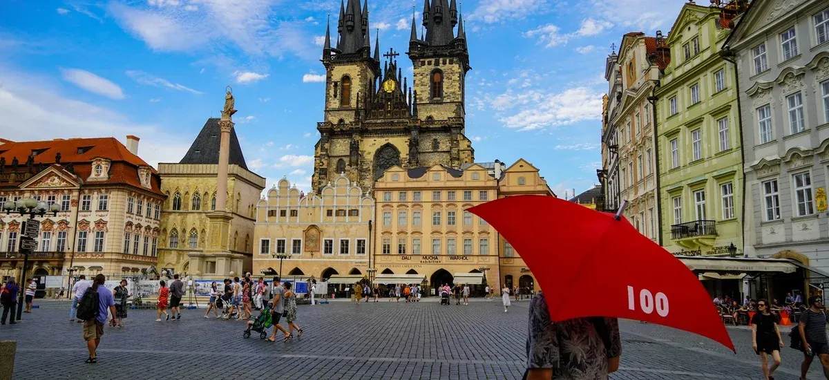Touristen erkunden den Altstädter Ring in Prag mit der Kirche Unserer Lieben Frau vor Týn im Hintergrund.