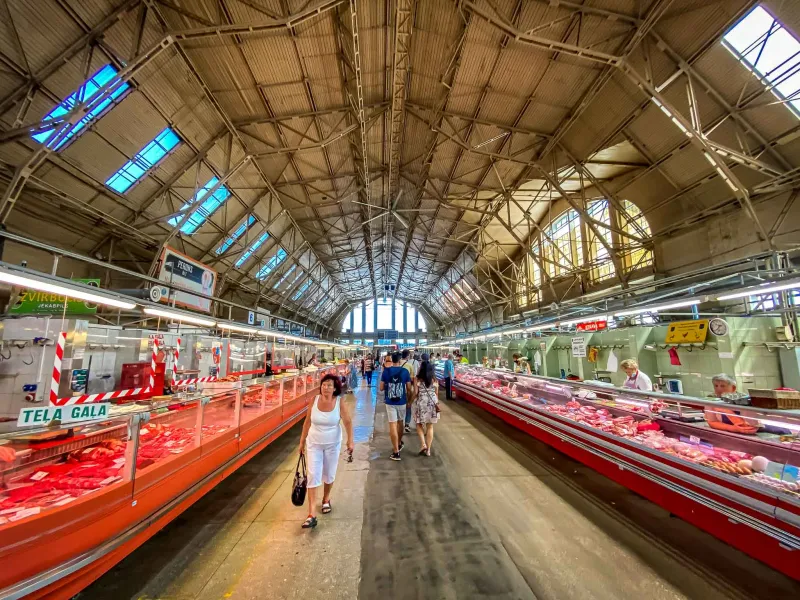 Los visitantes exploran la impresionante sala de carne del Mercado Central de Riga en Letonia.
