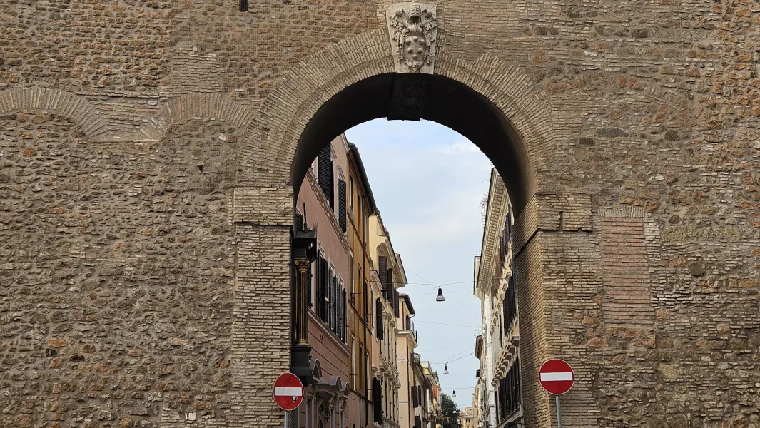 Antiguo arco romano en Roma, ofreciendo una vista de una encantadora calle.
