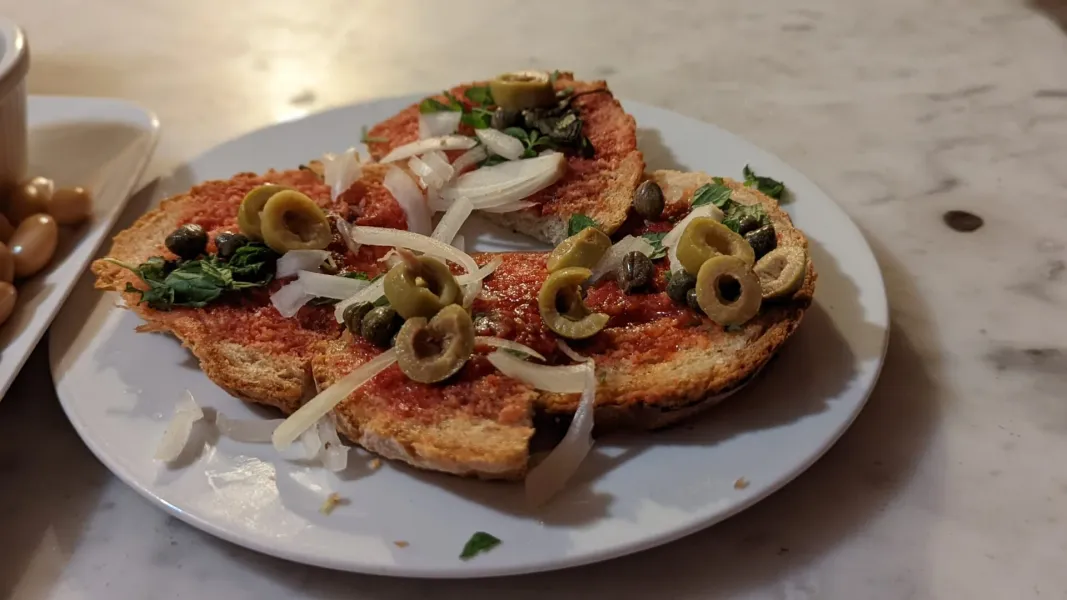 Deliciosas tapas con aceitunas y alcaparras sobre pan tostado en Roma.