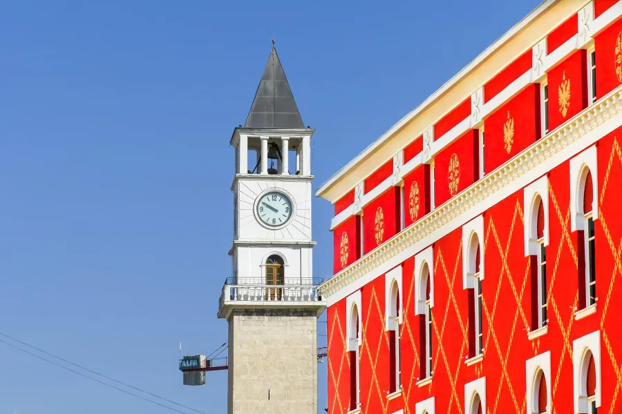 Zegar wieża w Tiranie i kolorowy budynek w historycznym centrum.