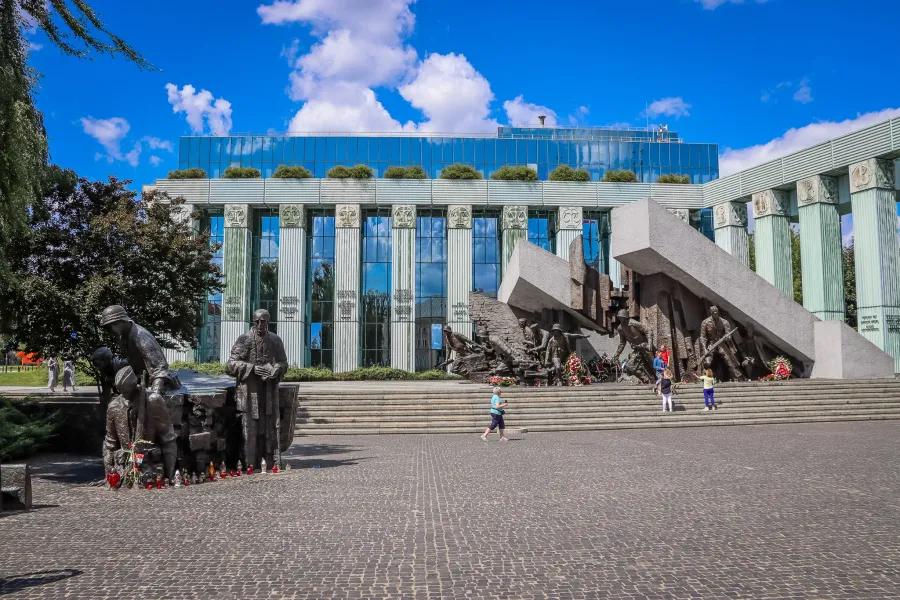 Tourists visit the poignant Monument to the Victims of the Warsaw Ghetto Uprising and the Palace of Justice in Warsaw.