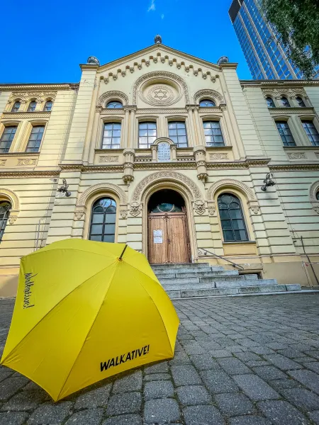 Yellow umbrella from Walkative! tour in front of the Nożyk Synagogue in Warsaw, Poland.