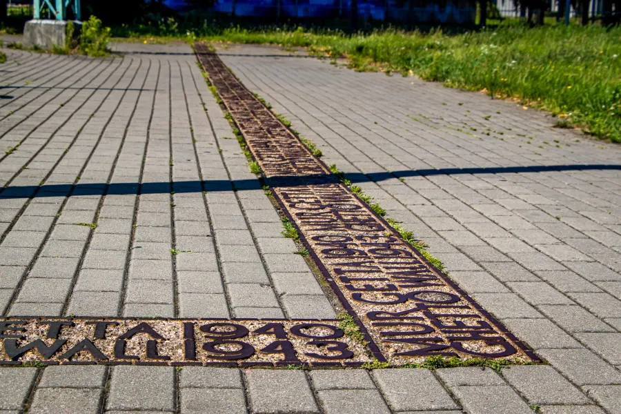 Metalowy wkład w chodniku w Warszawie oznacza lokalizację Muru Getta, upamiętniając lata 1940-1943.