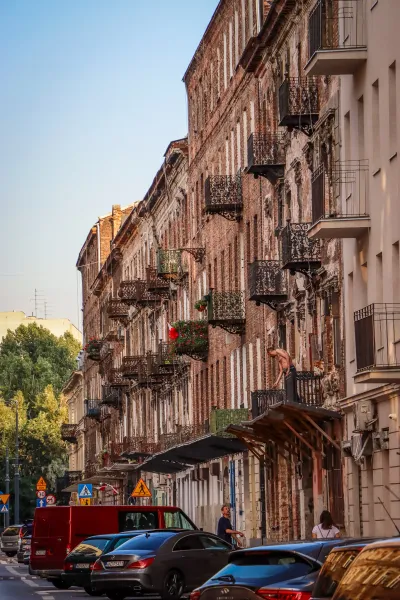 Edificios históricos con balcones ornamentados bordean una calle de Varsovia.