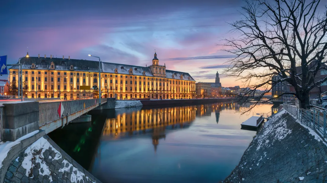 Universität Wrocław in der Abenddämmerung, reflektiert in der Oder.