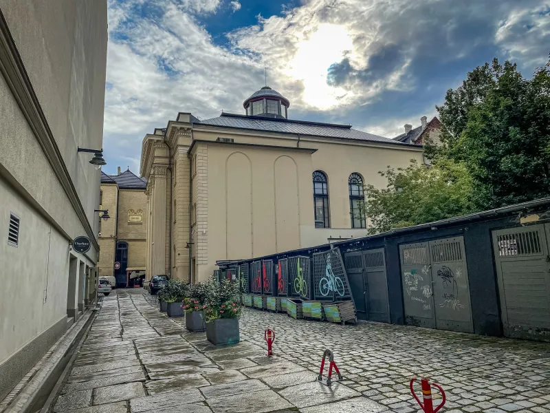 Urocza brukowana uliczka we Wrocławiu, Polska, z zabytkowym budynkiem i kolorowymi stojakami na rowery.