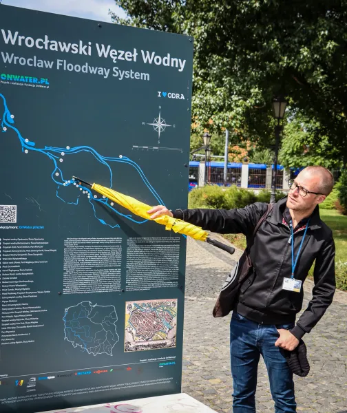 Ein Reiseleiter in Wrocław, Polen, zeigt auf eine Karte des Hochwasserschutzsystems der Stadt.