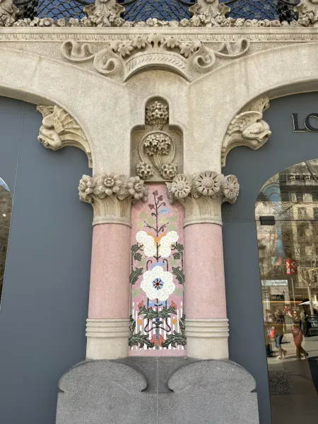 Floral mosaic and carved stone columns at Casa Lleó Morera's facade on Passeig de Gràcia, Barcelona.