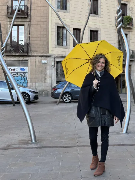 Walkative tour guide holding a yellow umbrella at Plaça de Sant Miquel in Barcelona.