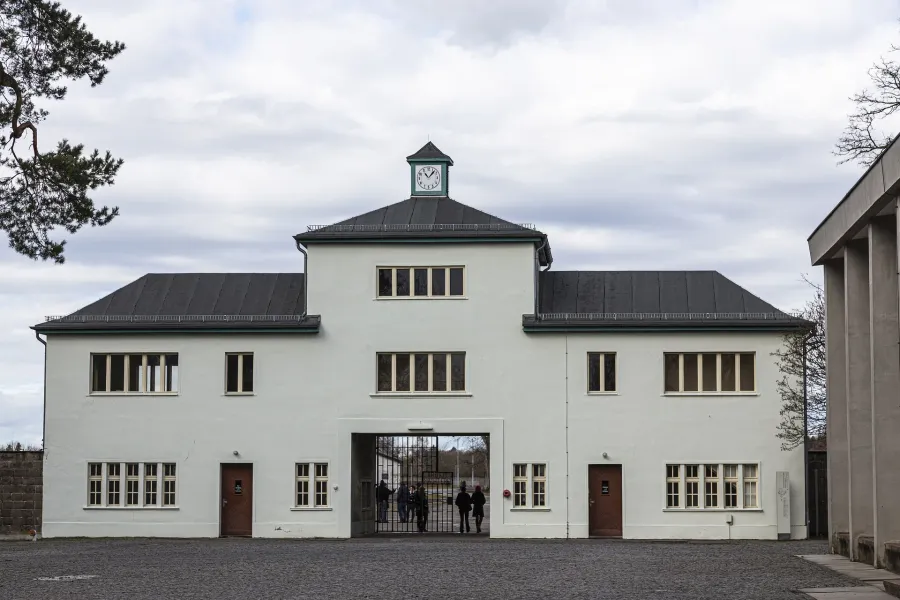 Brama wejściowa do miejsca historycznego, z turystami przechodzącymi przez nią.