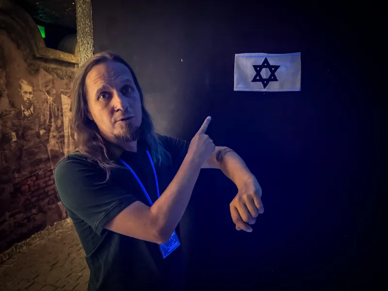 Tour guide pointing to a Jewish arm band with a Star of David at Schindler's Factory Museum in Krakow.