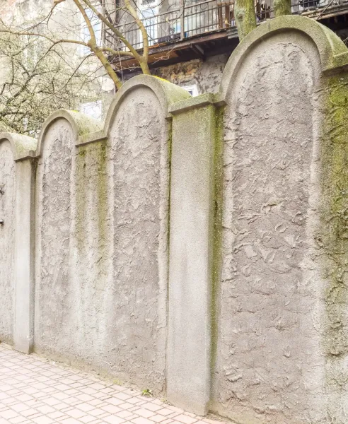 Ein Abschnitt der Krakauer Ghettomauer, deren Bögen jüdischen Grabsteinen (Mazewot) nachempfunden sind.