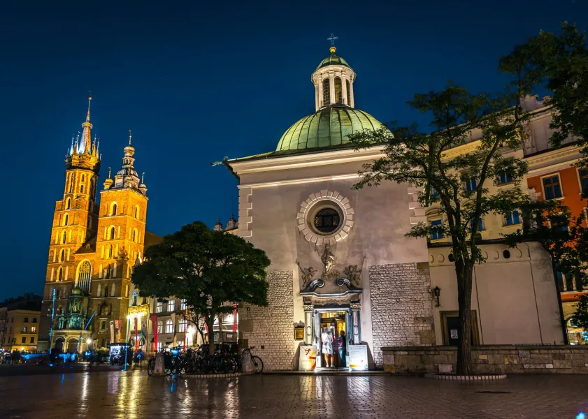 St. Adalbert's Church and St. Mary's Basilica on the Main Market Square in Krakow, illuminated at night.