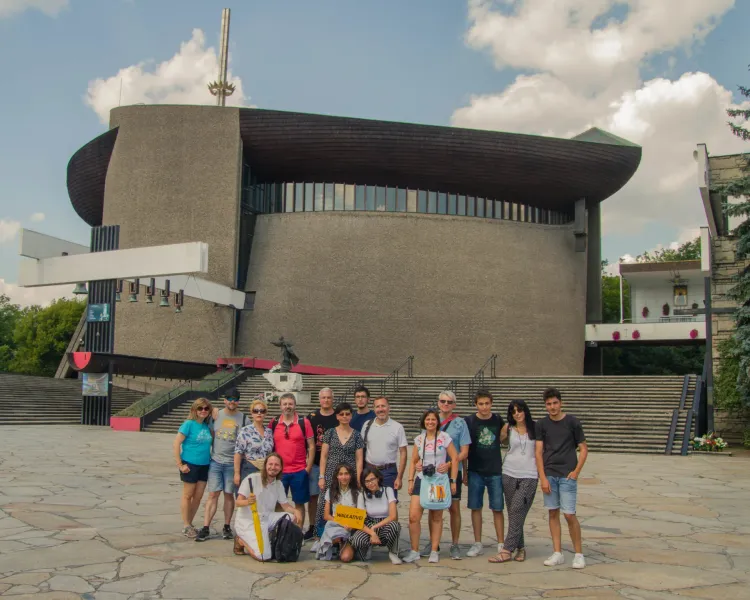 A Walkative tour group poses for a photo in front of the modern Lord's Ark church (Arka Pana) in Nowa Huta, Krakow.